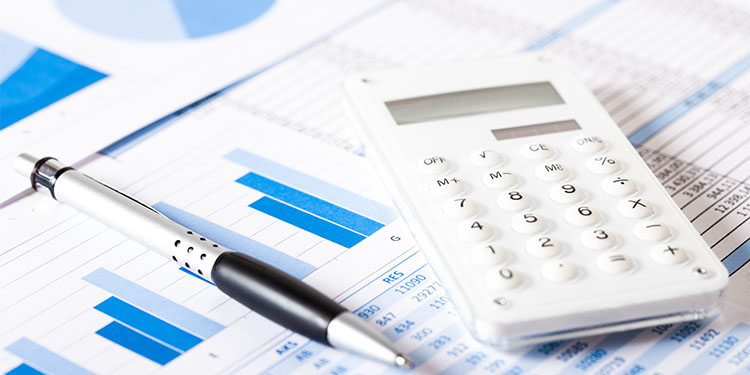 Financial documents, calculator, and pen placed on desk. 