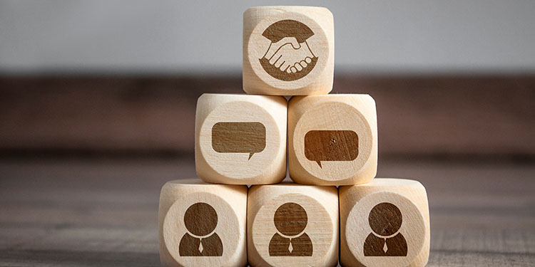 Negotiation depicted with wooden blocks with hand shake symbols.