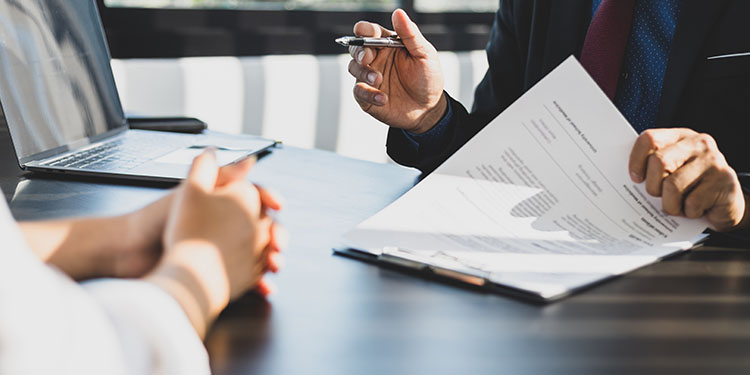 Contract negotiation between three parties seated at a conference table.