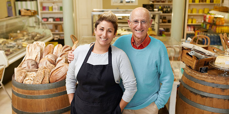 Father and daughter bakery business owners in shop.