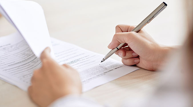 Signing business sale closing documents.