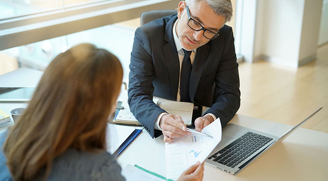 Business buyer securing financing from lender in bank office. 