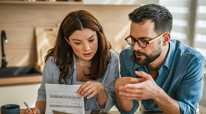 Husband and wife discussing small business succession planning in kitchen setting. 