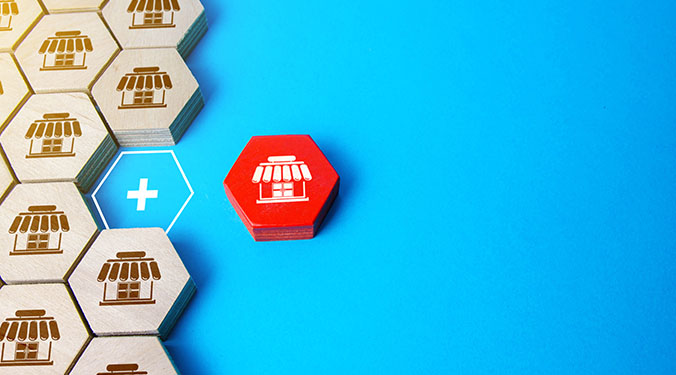 Franchise icons on wooden blocks against blue background.