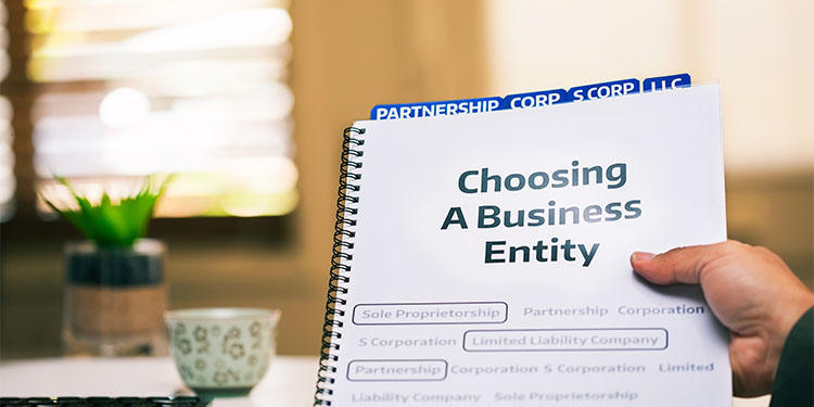 Spiral notebook highlighting business entity options, partnership, corp, s-corp, and LLC tabs.