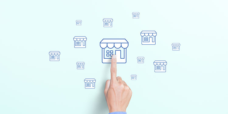 Franchise business model depicted with wooden cubes with storefront icons on blue background.
