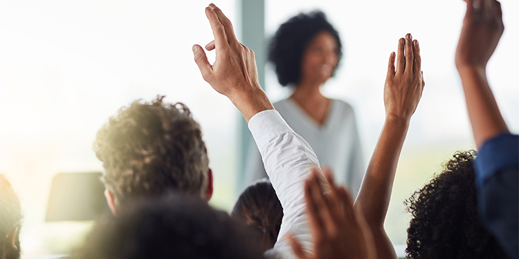 Woman leading training session with hands raised for questions.