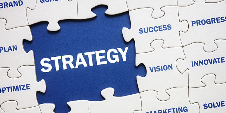 The word "strategy" written as part of a puzzle piece that fits with business terms.
