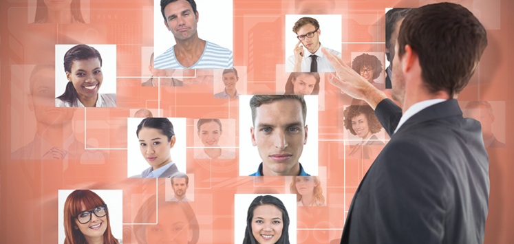 Person standing in front a screen picking from different pictures of people. Depicting qualified buyers for a small business.