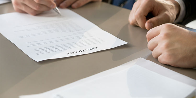 Business people at table signing contracts. 