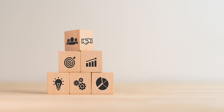Wooden cubes with valuation icons displayed in a pyramid. 