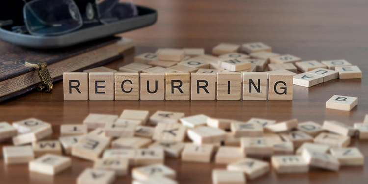 The word 'recurring' spelled out in Scrabble tiles.