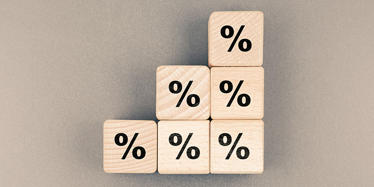 Percentage symbol on six wooden blocks arranged like steps up. 