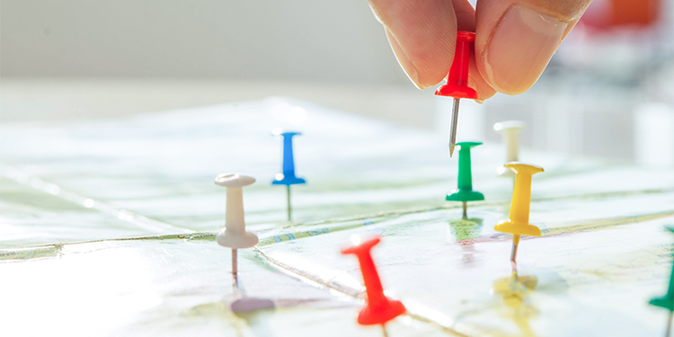 Push pins on map symbolizing multiple locations.