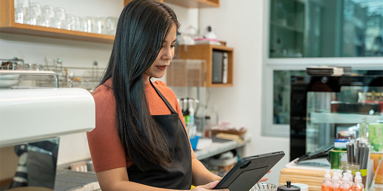 Small business owner surveying inventory in a coffee shop.