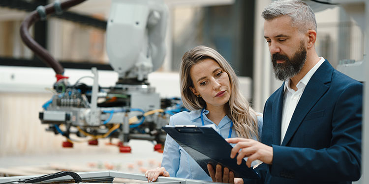 Business owner training employee of manufacturing business.