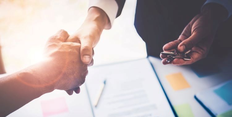 Business owners shaking hands after closing a deal.