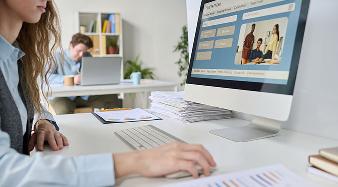 Small business owner sitting at computer writing an online listing for a business for sale.