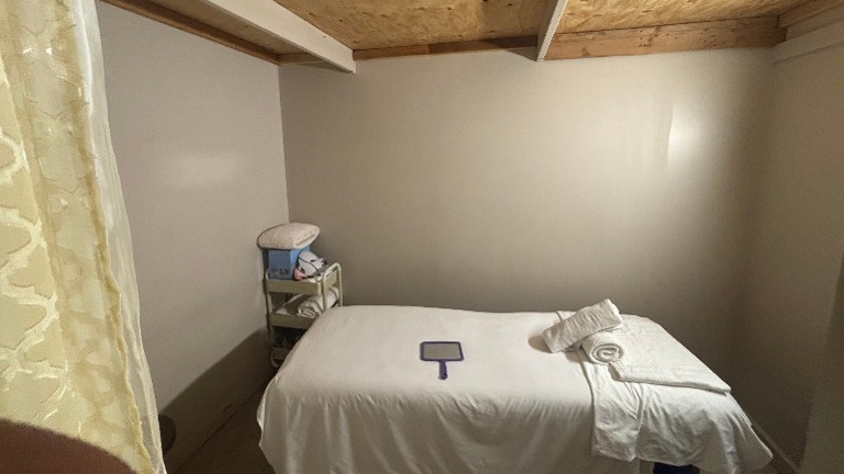 Alternate view of facial room with supply cart and storage.