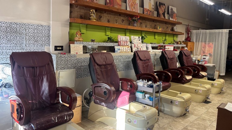 Pedicure massage chairs with built-in foot spa basins, ready for client use.